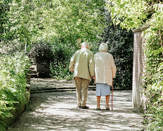 An elderly couple walking arm in arm