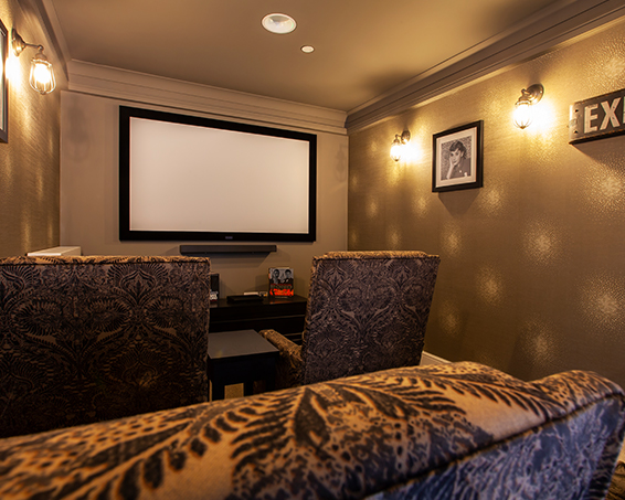 Projector and comfy seats in the cinema room at Penrose Court Care Home