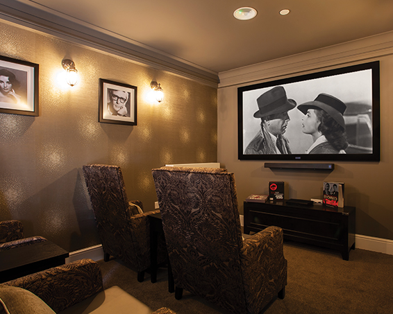 Projector and comfy seats in the cinema room at Penrose Court Care Home