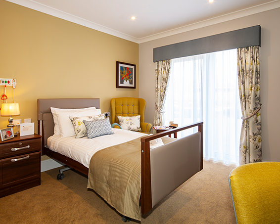 A bedroom at Penrose Court Care Home with yellow furnishings