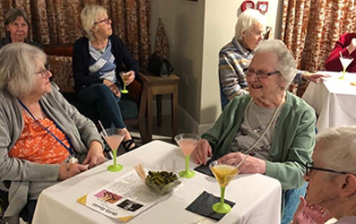 Penrose Court Care Home residents sat around a table having a drink