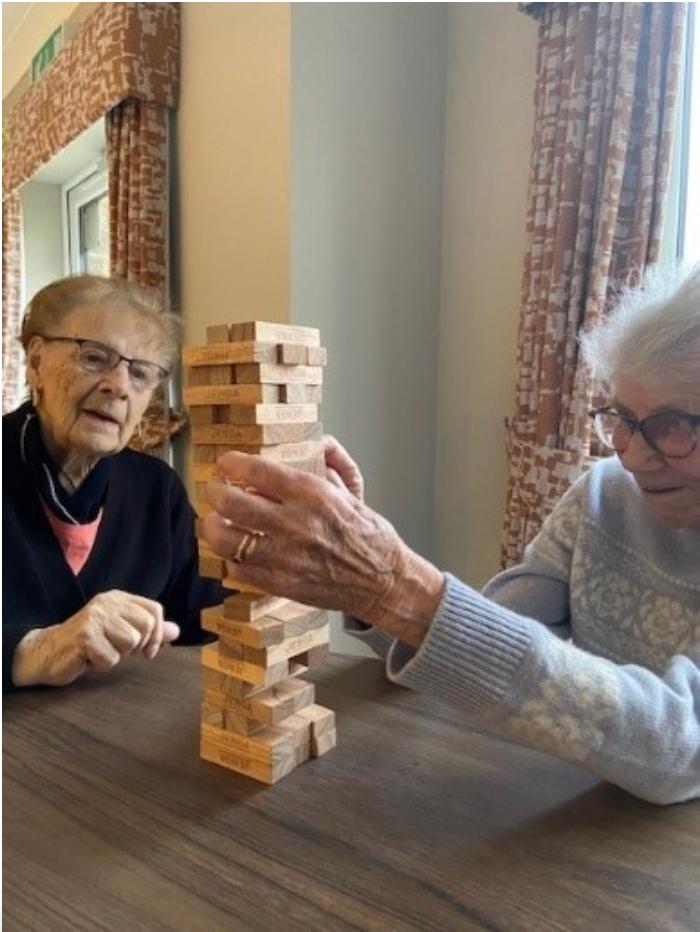 residents sat together playing Jenga