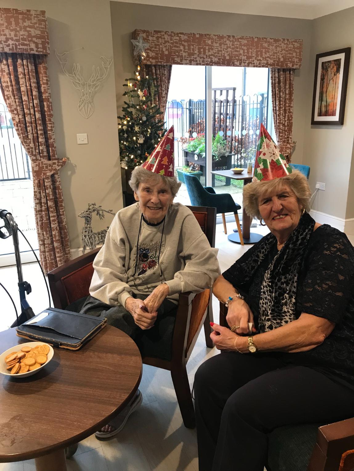 residents enjoying a christmas meal together with themed hats on